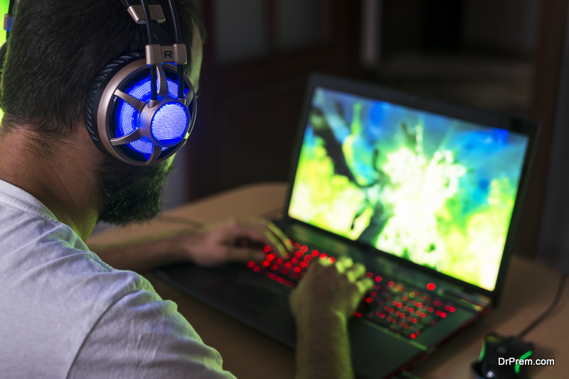 young man playing games on gaming laptop