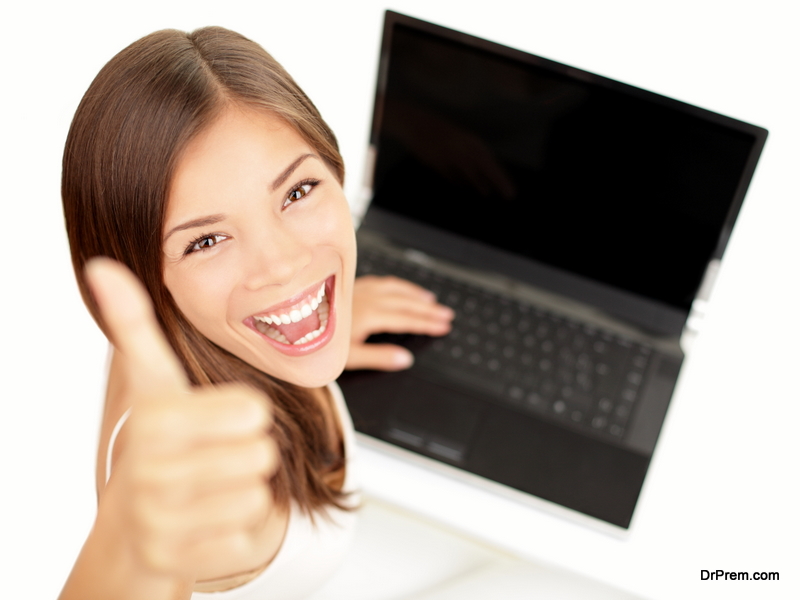 Laptop woman happy giving thumbs up success sign sitting at computer PC 