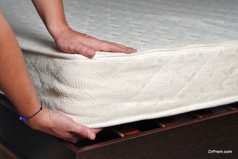 Hand of man testing the firmness of white mattress