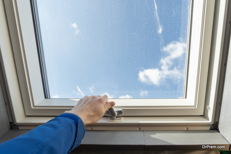 Cropped view of one workman open new plastic window on roof, holding hand on frame handle