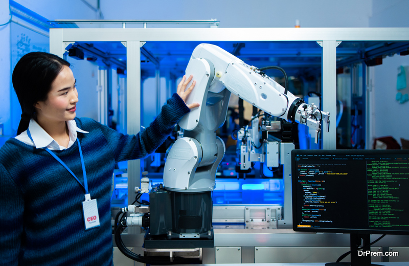 Meeting asian Engineers Maintenance Robot Arm at Lab. they are in a High Tech Research Laboratory with Modern Equipment. smiling multicultural businesspeople looking at camera while standing near robot.